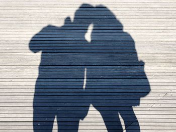 Shadow of man and woman standing on boardwalk