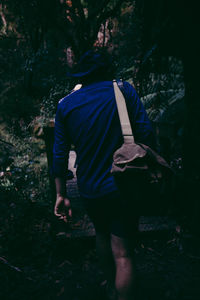 Rear view of man walking in forest