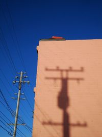 Low angle view of power lines against blue sky