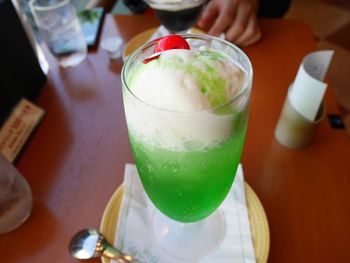 Close-up of hand holding drink on table