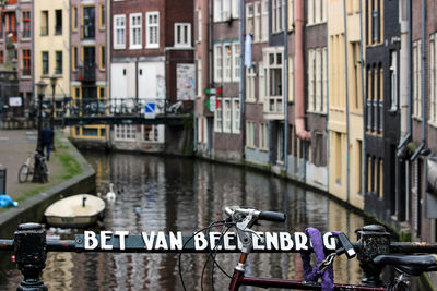 Boats in canal amidst buildings in city