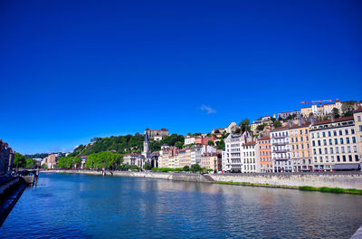 Buildings in city against blue sky