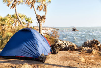 Tent on beach by sea against sky