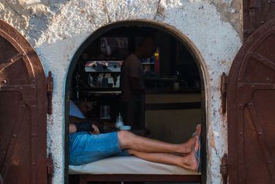 Man sitting on old door