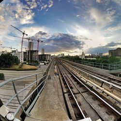 Railroad track against cloudy sky