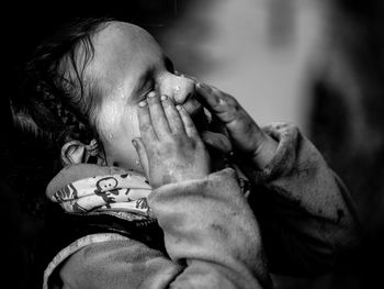 Close-up of wet girl covering eyes