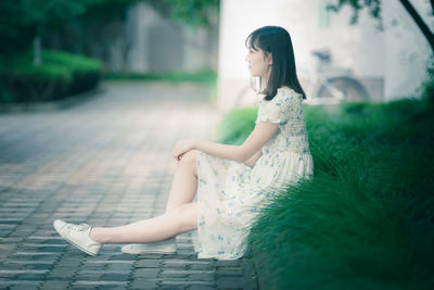 Side view of a girl sitting outdoors