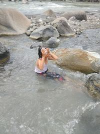 Woman standing on rock in sea