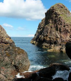 Scenic view of rocks in sea against sky