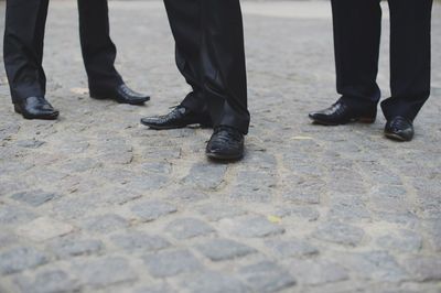 Low section of men standing on street