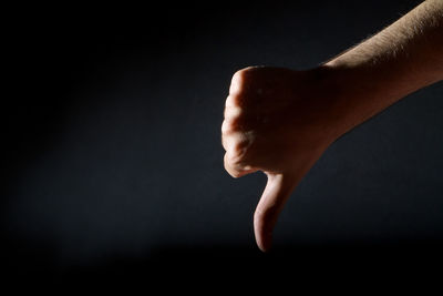 Close-up of human hand against black background