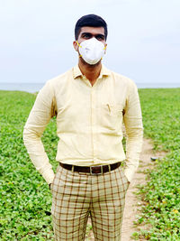 Portrait of young man standing on field