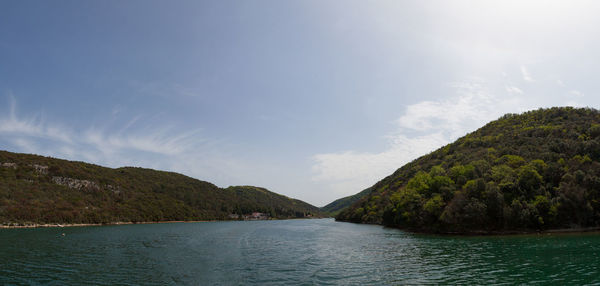 Scenic view of sea and mountains against sky