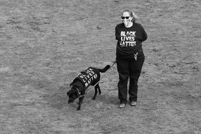 Portrait of man with dog standing on field