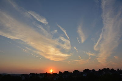 Silhouette townscape against sky during sunset