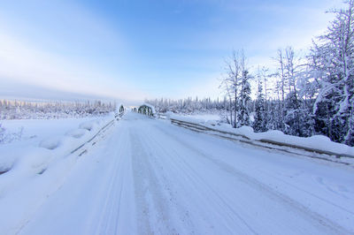 Snow covered road against sky