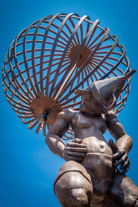 Low angle view of sculpture against blue sky