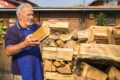 Senior man stacking logs