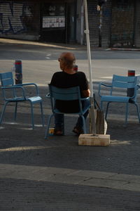 Man sitting on chair at street