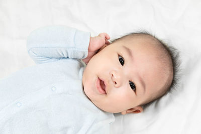 Portrait of cute baby lying on bed