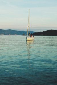 Sailboat sailing on sea against sky