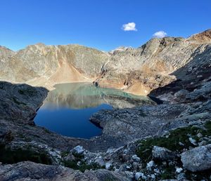 Scenic view of lake and mountains against blue sky