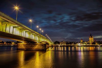 Illuminated bridge over river at night