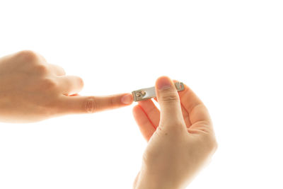 Close-up of hand holding hands over white background