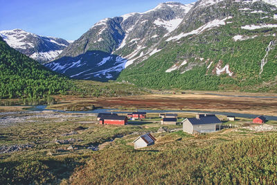 Scenic view of agricultural field by houses and mountains