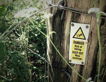 Close-up of warning sign on fence