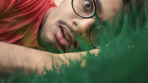 Close-up portrait of young man lying outdoors