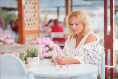 Portrait of woman drinking beer at beach cafe