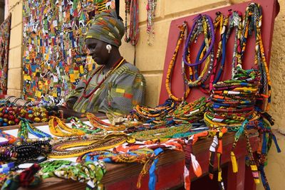 Mid adult woman selling colorful personal accessories at market stall