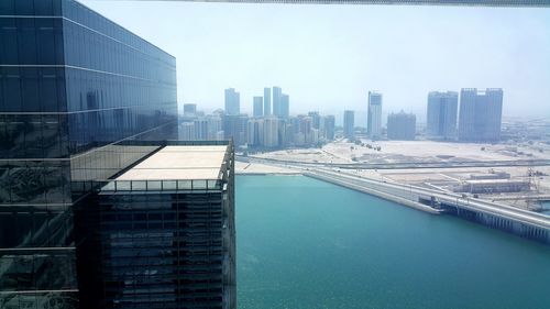 Buildings by swimming pool in city against sky