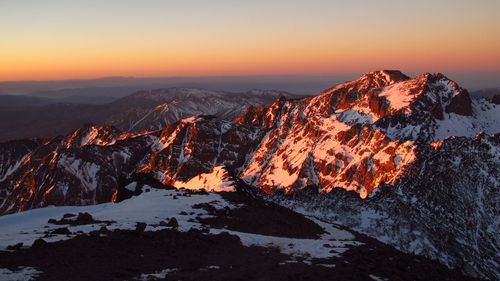 Scenic view of snowcapped mountains against sky during sunset