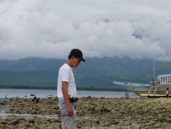 Side view of man standing at beach