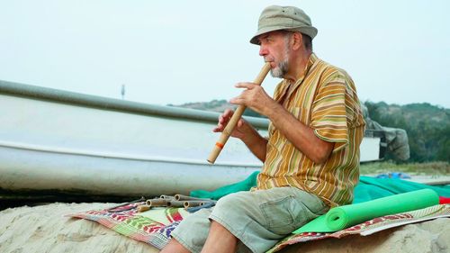 Man holding umbrella against sky