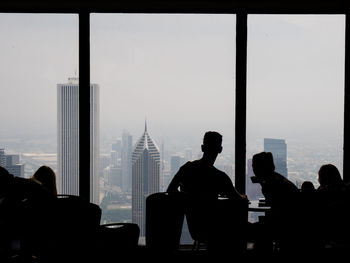 Silhouette of people enjoying a drink with a view on chicago's skyline