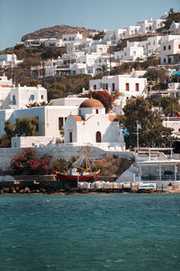 Buildings by sea against sky