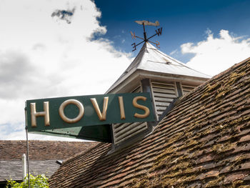 Low angle view of sign on building against sky