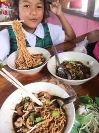 High angle portrait of girl eating food on table