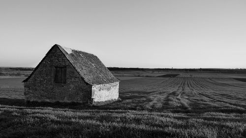 House on landscape against clear sky