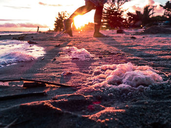 Surface level of beach against sky during sunset