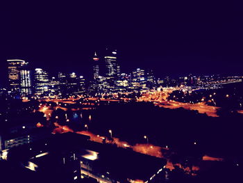 High angle view of illuminated cityscape against sky at night