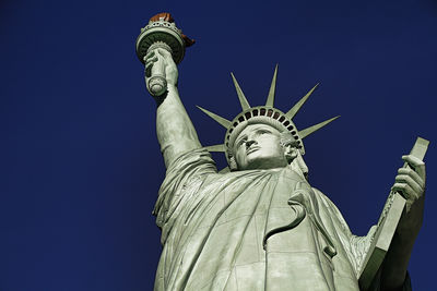 Low angle view of statue against blue sky