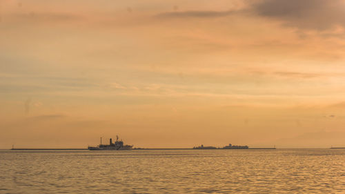 Scenic view of sea against cloudy sky during sunset