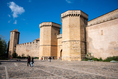 Group of people in front of fort against sky