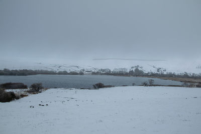 Snow covered landscape against sky