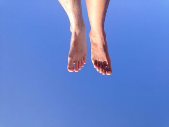 Low section of woman against clear blue sky