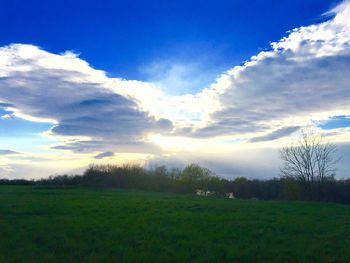 Scenic view of grassy field against cloudy sky